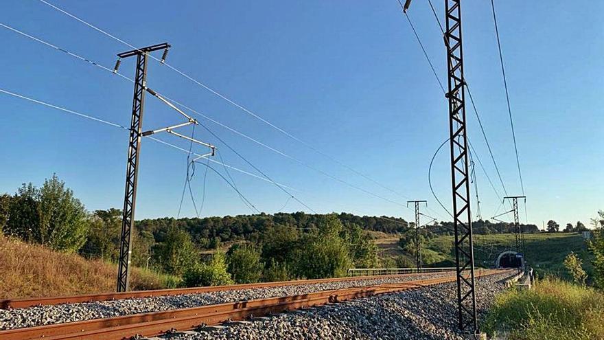 A l&#039;esquerra, la catenària tallada, i a la dreta, les restes dels objectes cremats a la via.