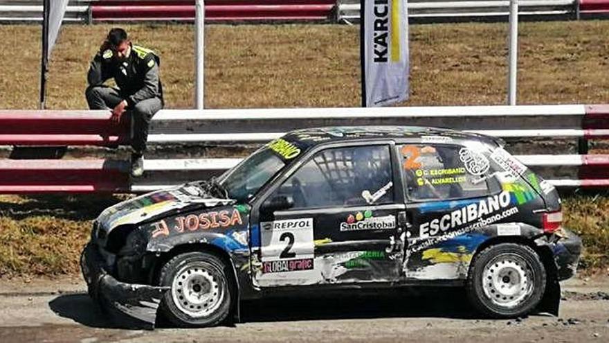 El piloto zamorano, cabizbajo, espera a la grúa junto a su coche averiado .