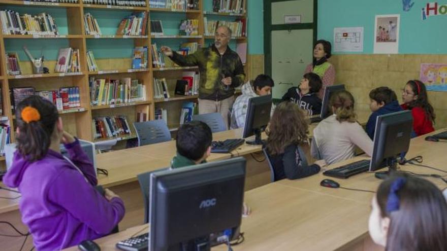 Casquero, profesor del centro y coordinador de la nueva biblioteca-mediateca, enseña a los alumnos la distribución de los libros.