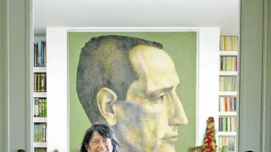 Elisa Delibes, hija del escritor, posa junto a un retrato de su padre.