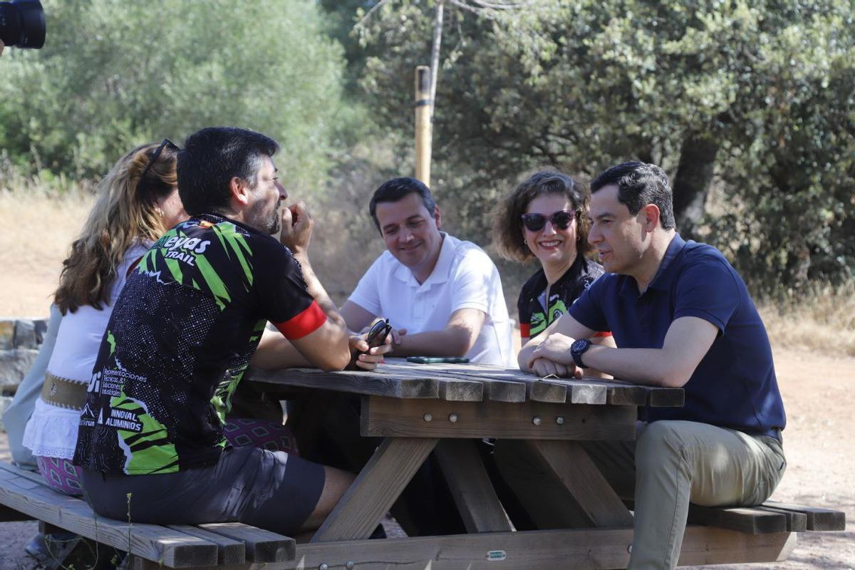Juanma Moreno, junto al alcalde de Córdoba, conversa con un grupo de senderistas.
