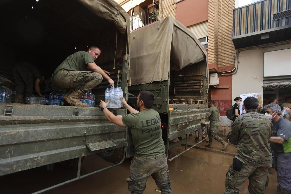 Legionarios reparten botellas de agua a los vecinos de una de las localidades más afectadas por la DANA