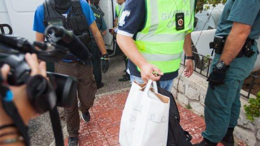 Un especialista del EDOA con una bolsa llena de drogas que encontraron en la casa durante el registro.