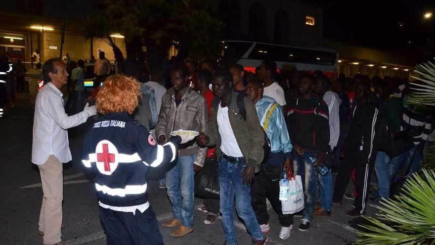 Miembros de la Cruz Roja atienden a inmigrantes bloqueados cerca de la frontera francesa.