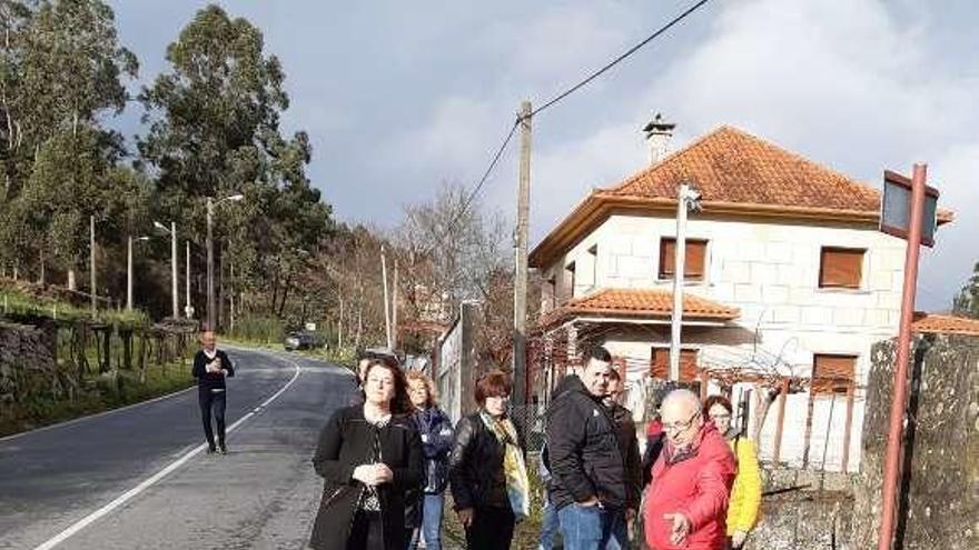 Los representantes del PP, ayer, con los vecinos de O Viso y Alxán por la carretera EP-2901 en la que eligen aceras. // FdV