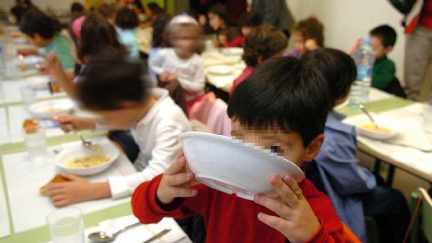 Un niño apura un plato de sopa en un comedor escolar.
