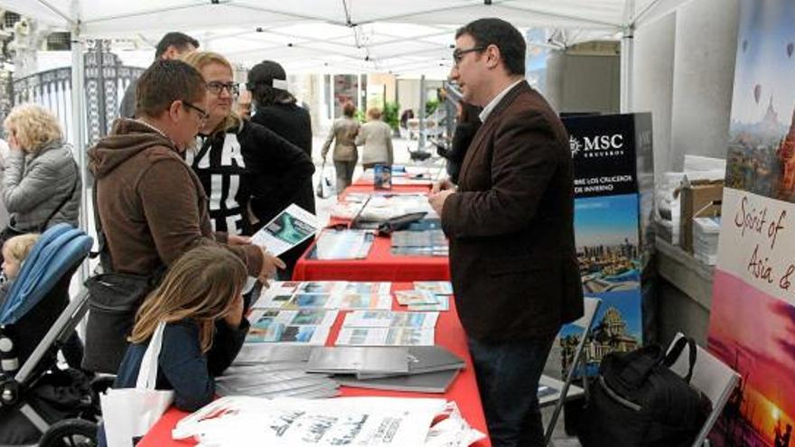 Persones consultant els diferents catàlegs de viatges dels estands que hi havia al pati del Kursaal