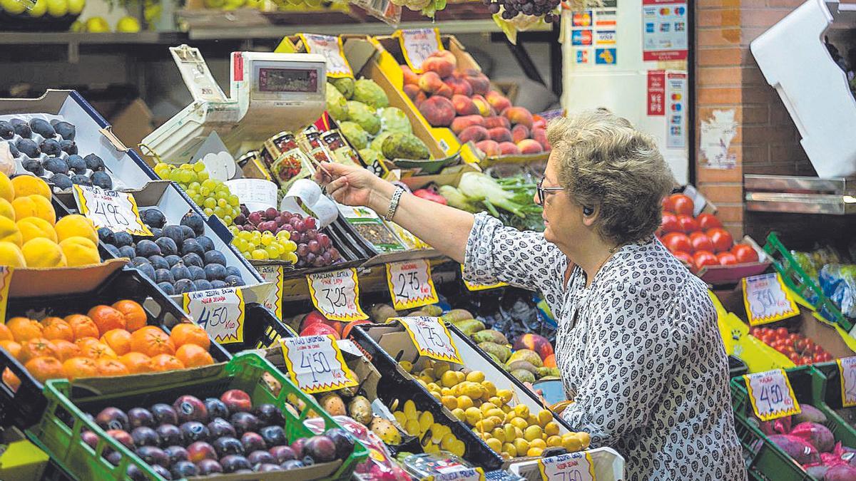 Una mujer comprando fruta.