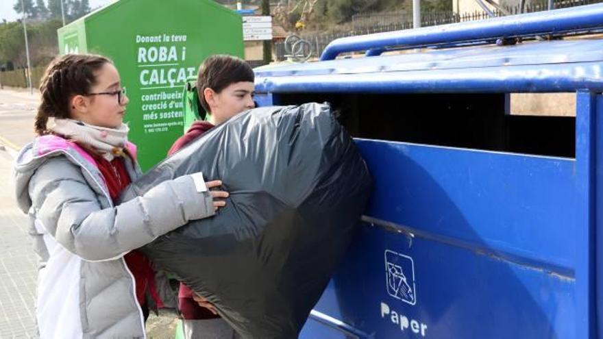 Dos alumnes de sisè de l&#039;escola Montserrat de Sant Salvador de Guardiola llençant els residus recollits