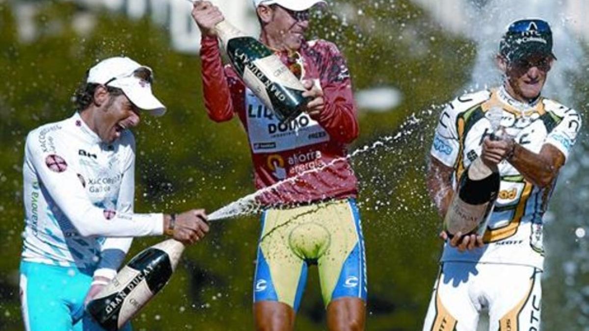 De izquierda a derecha, Ezequiel Mosquera (2º de la general), Vincenzo Nibali (1º) y Peter Velits (3º) se rocían con cava en el podio de Madrid, ayer.