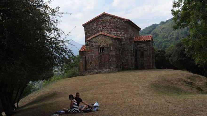 Dos turistas, ante la iglesia de Santa Cristina de Lena.