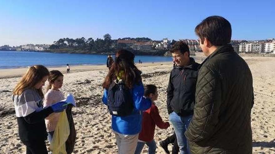 Los ediles Deza y Guisasola con escolares en la playa de Silgar.