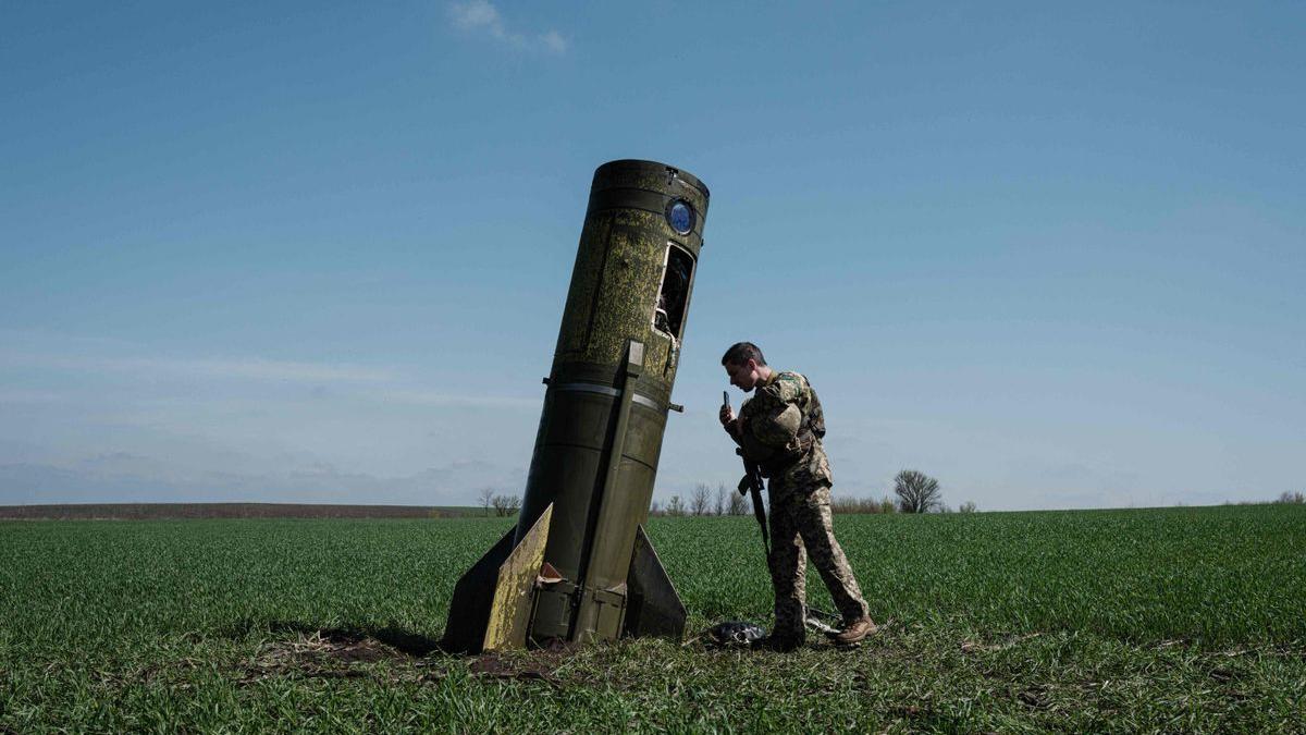 Un soldado ucraniano contempla los restos de un misil balístico ruso.