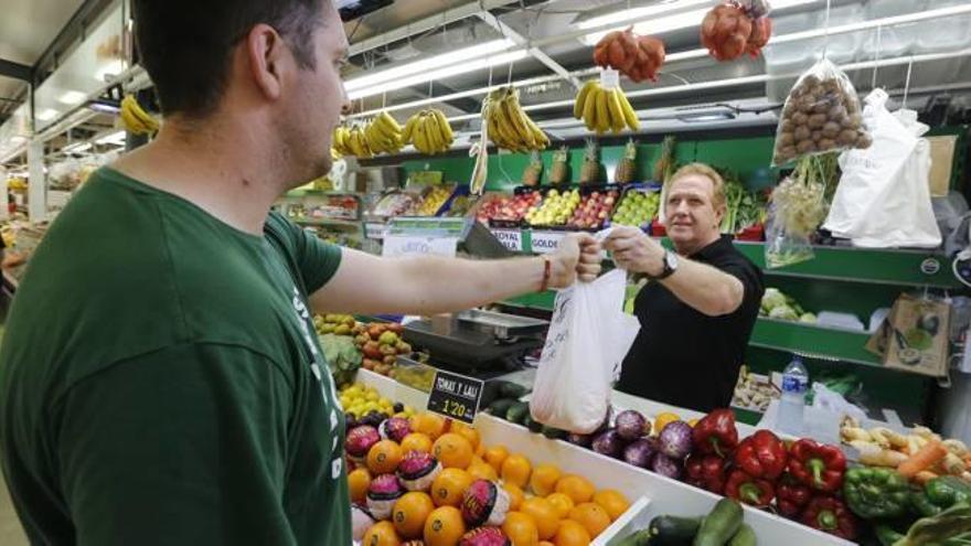 Un joven ilicitano realiza, durante el mediodía de ayer, su compra en uno de los puestos de frutería del Mercado Provisional de Elche.