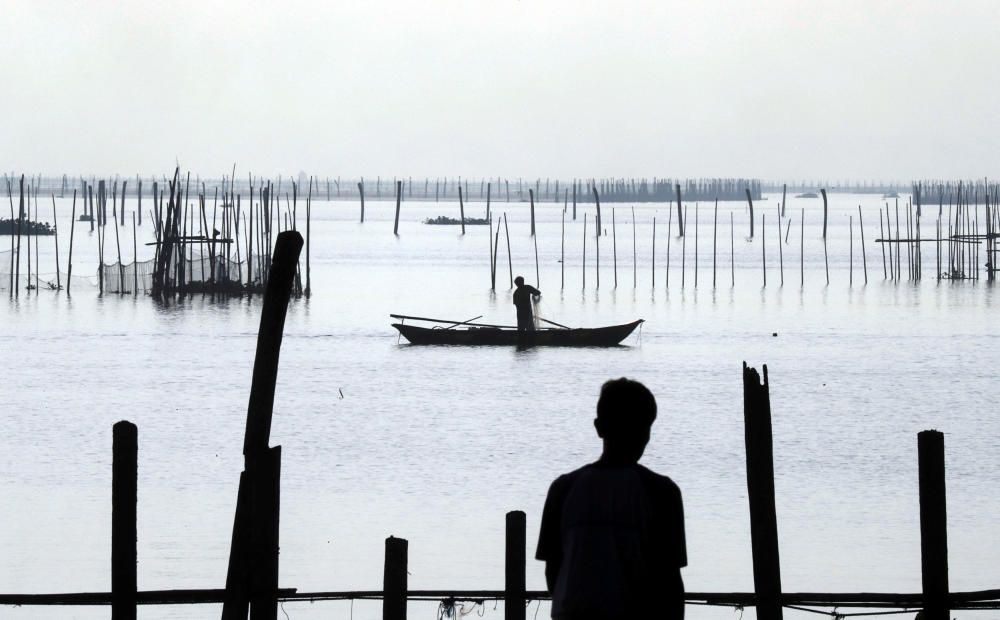 A worker recovers net in a fish pen before Super ...