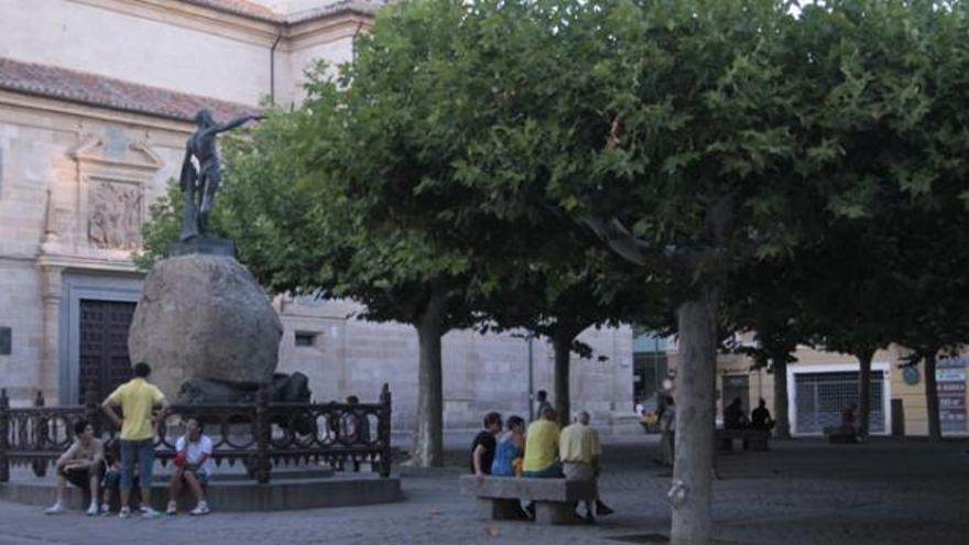 Varios turistas sentados ayer junto a la verja que rodea la escultura de Viriato.