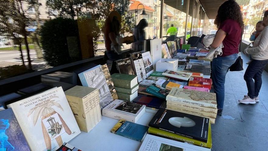 Lectores, en el puesto de recogida gratuita de libros instalado por el Concello de Cangas. | S.Á.