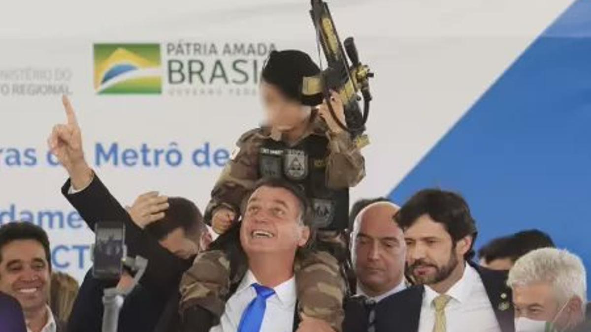 Bolsonaro, con el niño vestido de militar y con una metralleta de juguete.