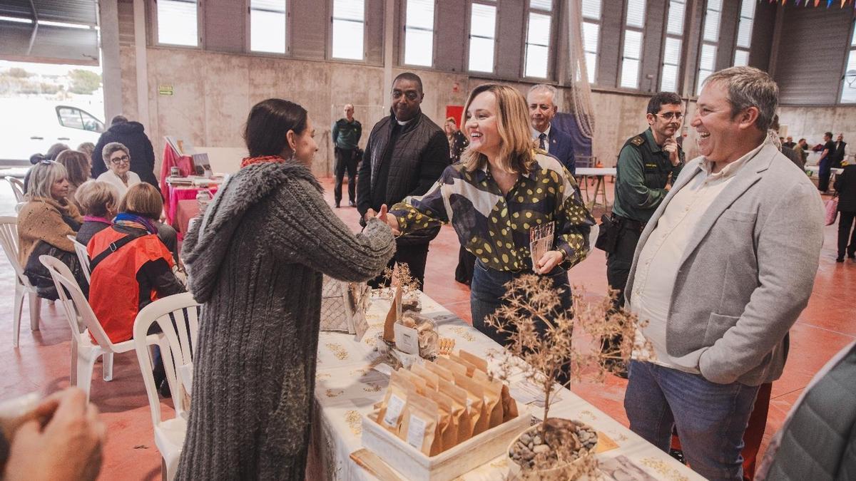 La ministra de Educación, Pilar Alegría, saluda a una mujer en el pabellón de Albalate de Cinca en presencia del alcalde Ricardo Chárlez y del Subdelegado del Gobierno en Huesca, José Carlos Campo