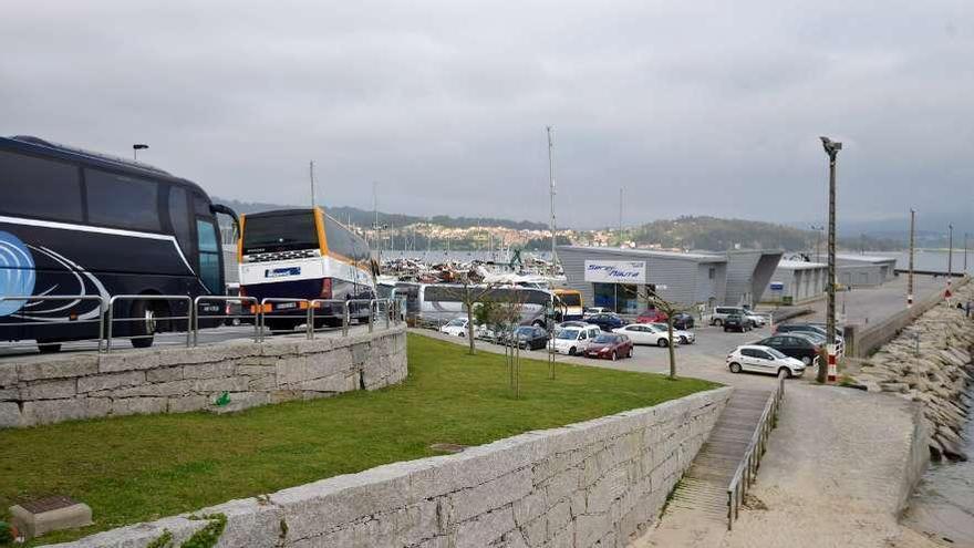 Los autobuses aparcados sobre la acera, con el puerto, al fondo, vacío.  // G. Santos