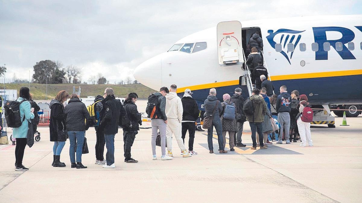 Una imatge d’arxiu de persones fent cua per entrar a un avió a l’aeroport de Girona.