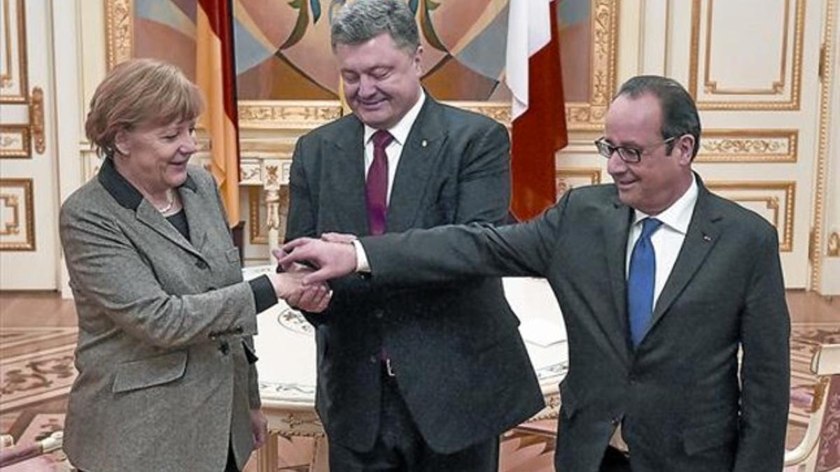 Merkel y Hollande, con el presidente ucraniano, Petró Poroshenko (en el centro), justo antes del inicio de la reunión, ayer, en Kiev.