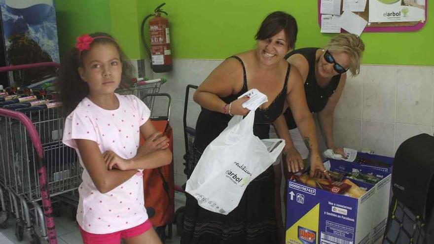 Voluntarias de la asociación y una niña saharui colocan los alimentos donados por los vecinos. Foto