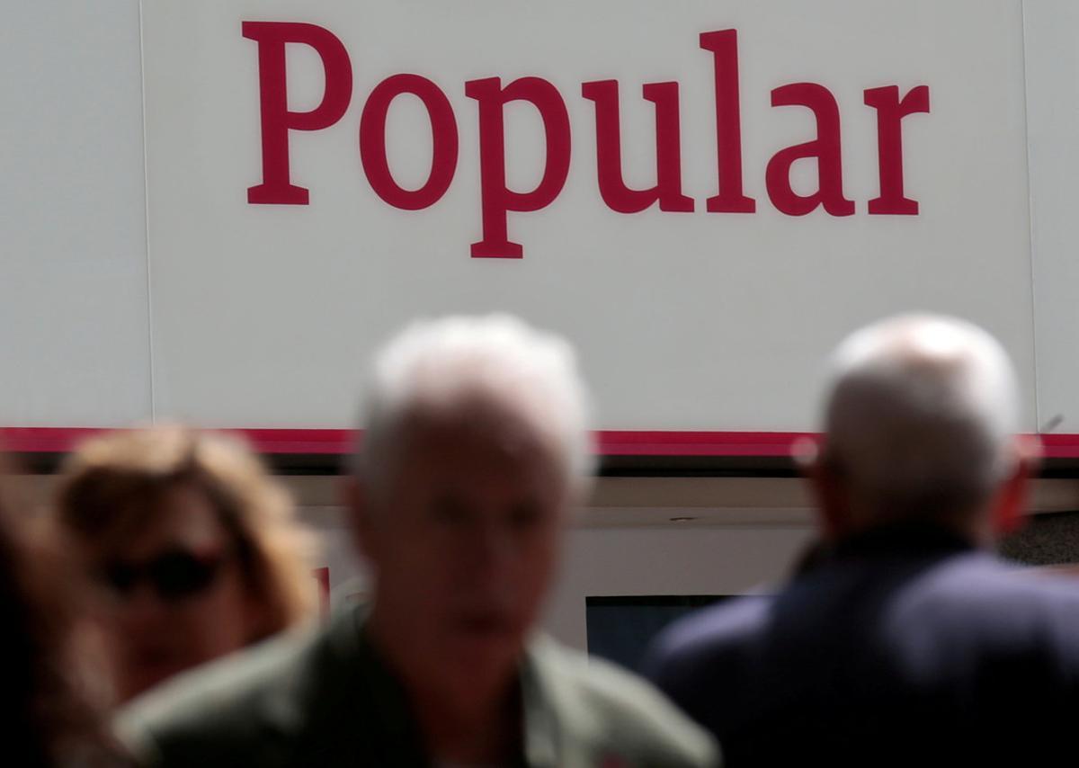 FILE PHOTO: People walk past a branch of Spain’s Banco Popular in Madrid, Spain, May 26, 2016. REUTERS/Andrea Comas/File Photo