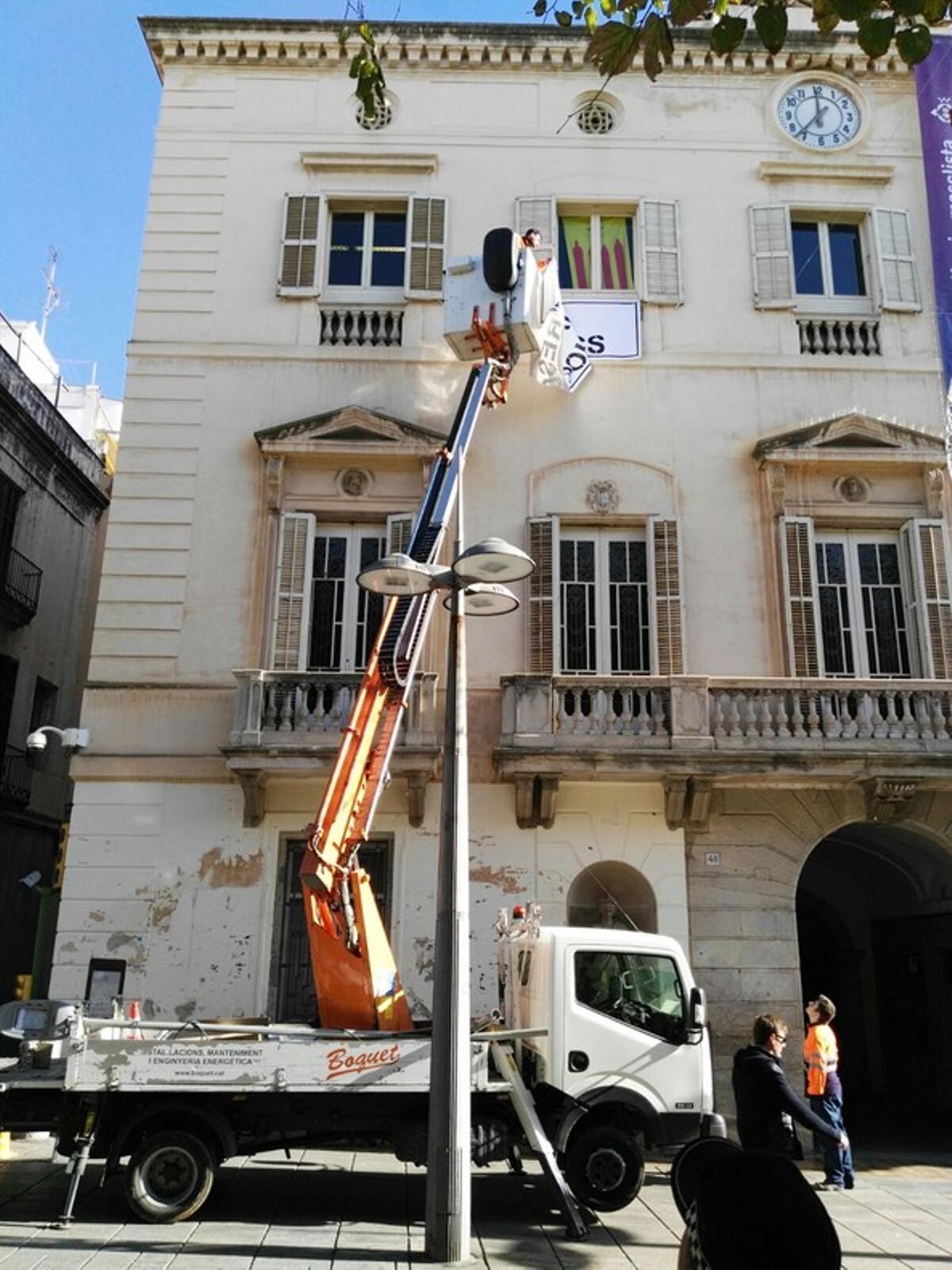 Moment en el qual una empresa externa de l’Ajuntament retira una pancarta a favor de l’alliberament dels presos que havien penjat a la façana de l’Ajuntament els grups d’ERC i CiU.