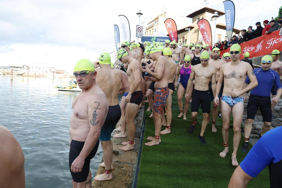 La travesía a nado de Navidad en Gijón congrega un año más a decenas de participantes (en imágenes)