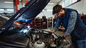 Mecánico verificando el estado del motor de un coche