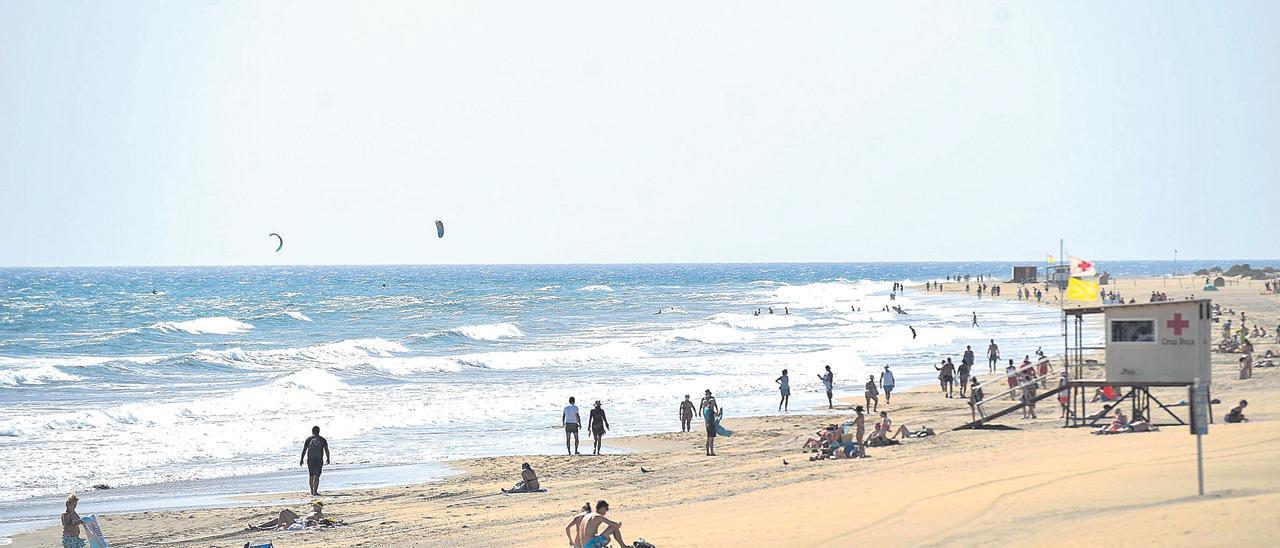 Varias personas disfrutan de un día soleado en Playa del Inglés, Gran Canaria.