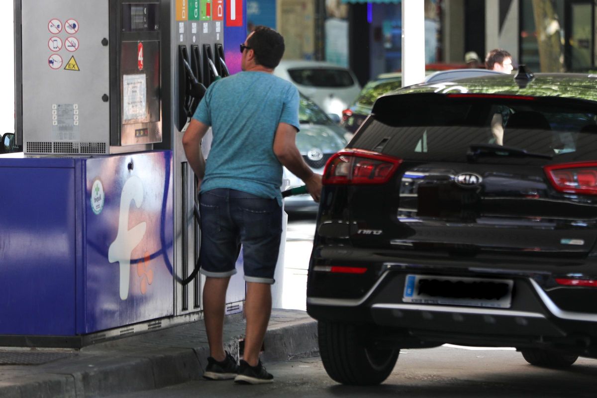 Personas ponen gasolina en sus coches en una gasolinera de Madrid.