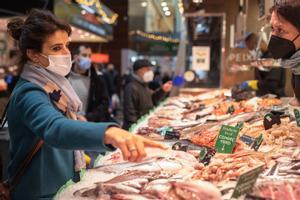Una mujer compra marisco en un mercado de Barcelona