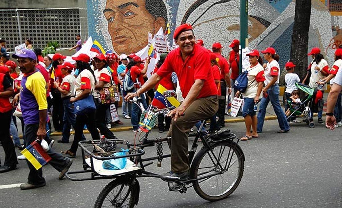 Un seguidor del president veneçolà Hugo Chávez va en bicicleta en una manifestació a Caracas pel Dia del Treballador.