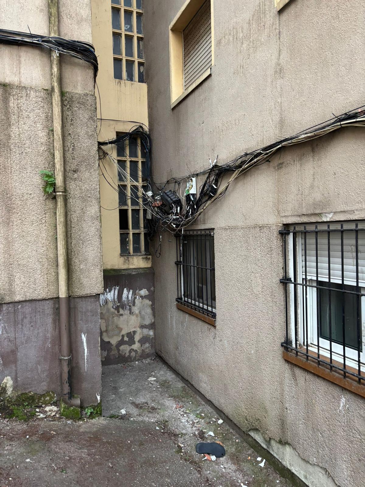 Cableria enredada i connexions a la vista en un dels blocs inspeccionats a Girona Est