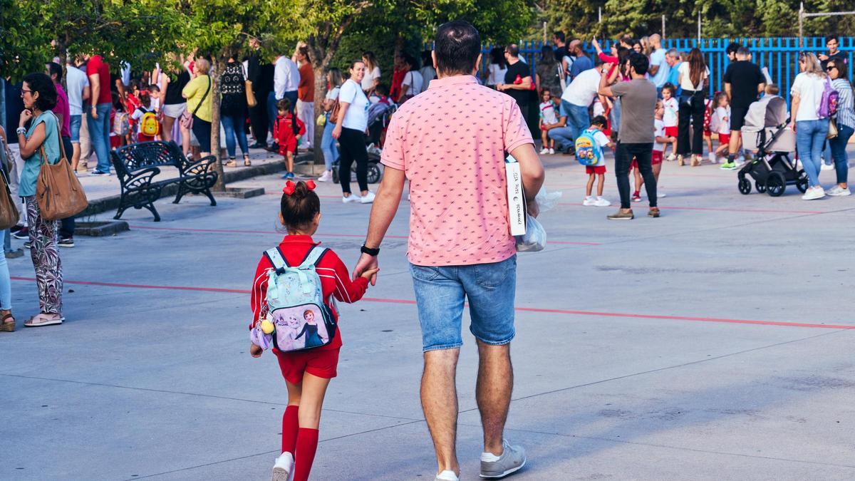 Un padre lleva a su hija menor al colegio.