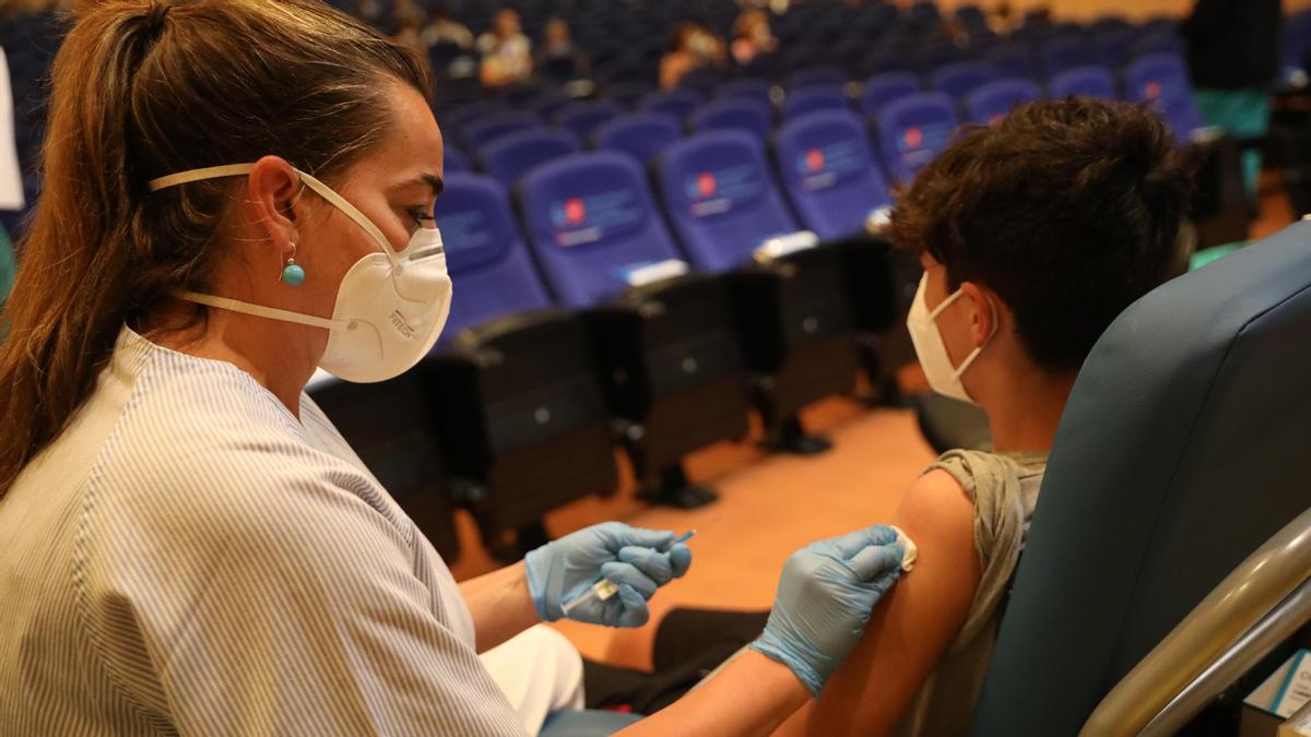 Una sanitaria vacuna a un menor.