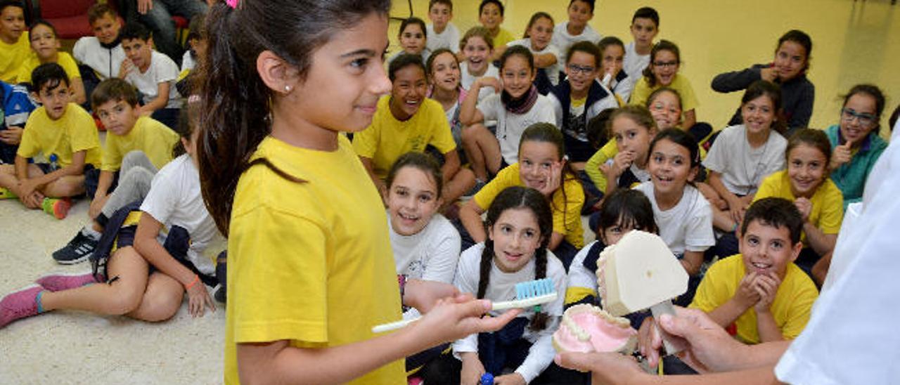 Una niña atiende las explicaciones sobre el cepillado.