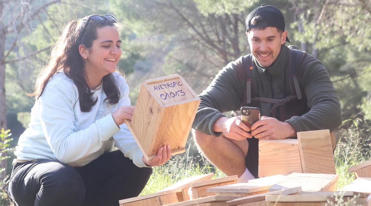 Dos voluntaris instal·len les caixes niu al cap de Creus.