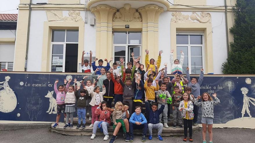 Los alumnos del colegio de Faes, con el mural del Principito recién estrenado, ayer, en el centro. | L. P.