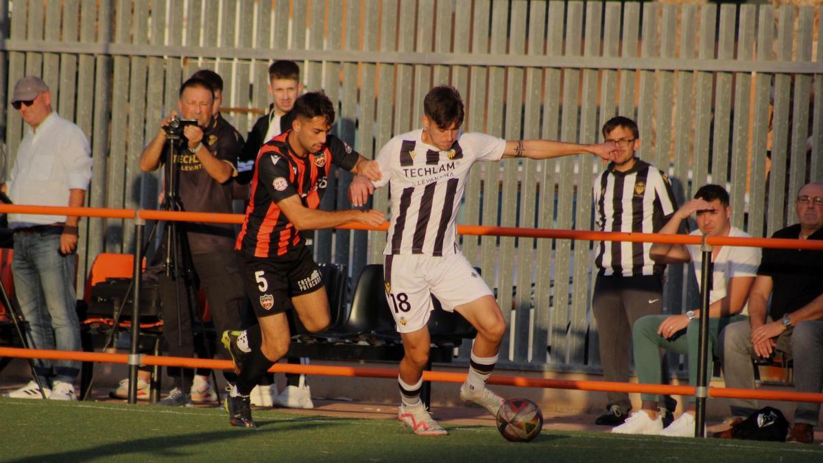 El delantero albinegro Iker Punzano intenta marcharse del marcaje del central local Marcos Cano.