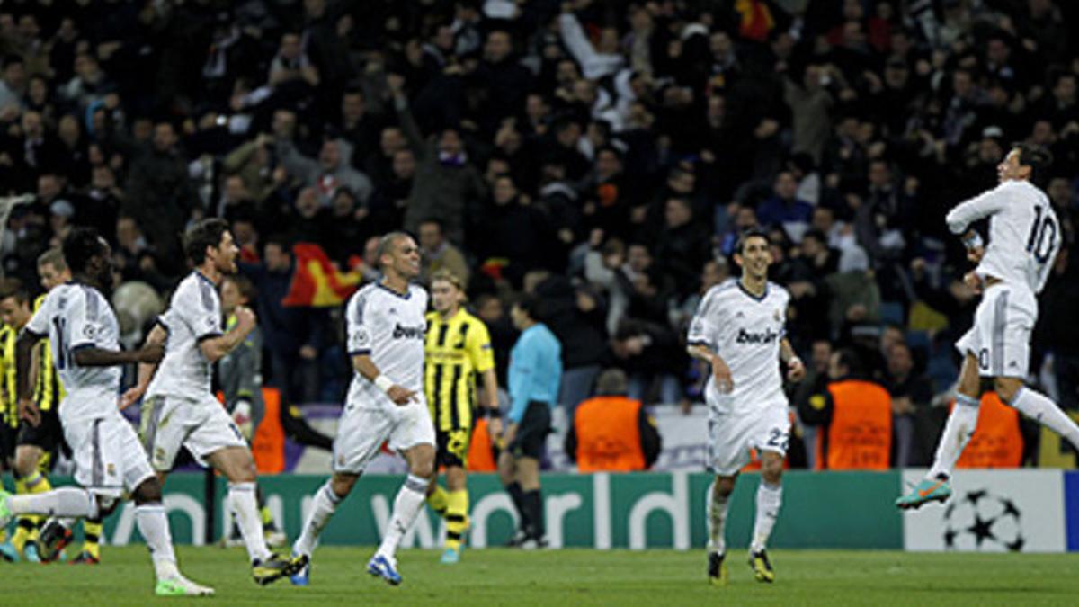 Los jugadores del Madrid acuden a felicitar a Özil, autor del gol del empate ante el Borussia