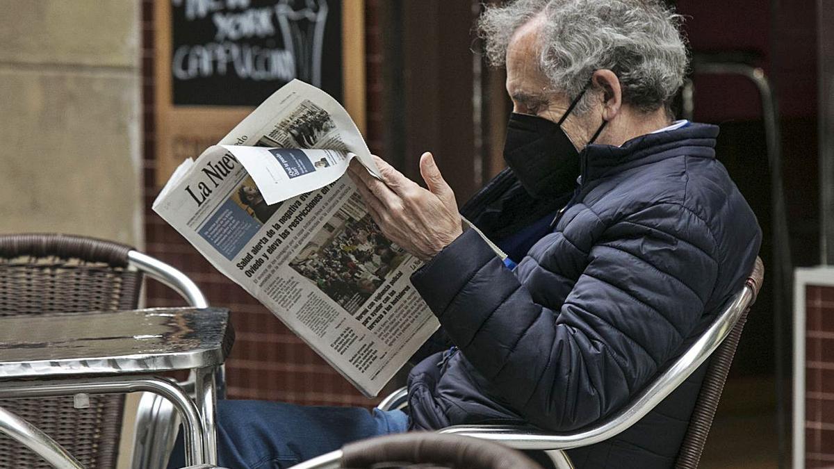 Un lector de LA NUEVA ESPAÑA, en una terraza en Oviedo. | Irma Collín