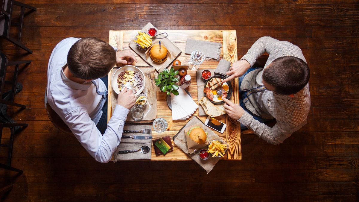 Dos amigos comparten una cena.