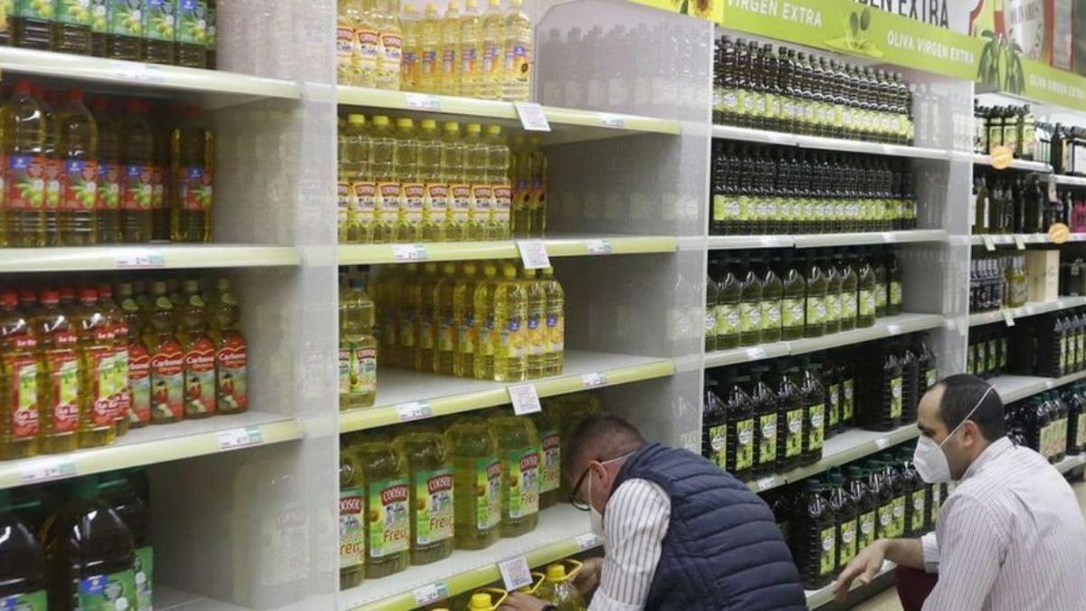 Profesionales trabajan con el aceite en un supermercado. A. J. GONZÁLEZ