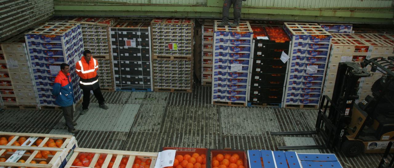 Unos trabajadores cargan un buque de naranjas en el puerto de Castelló.