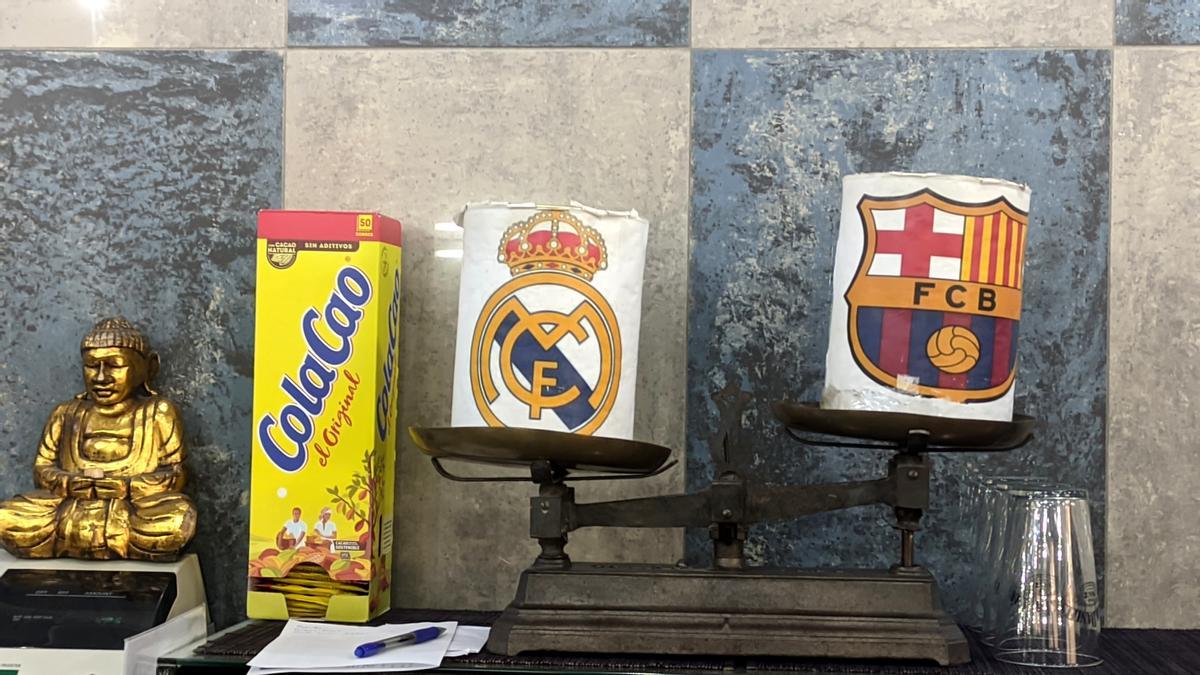 Las huchas para las propinas con los escudos del Barça y el Real Madrid del Bar Oliva.