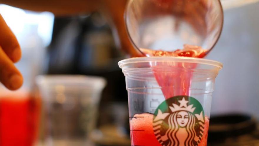 Un empleado de Starbucks sirve un refresco.