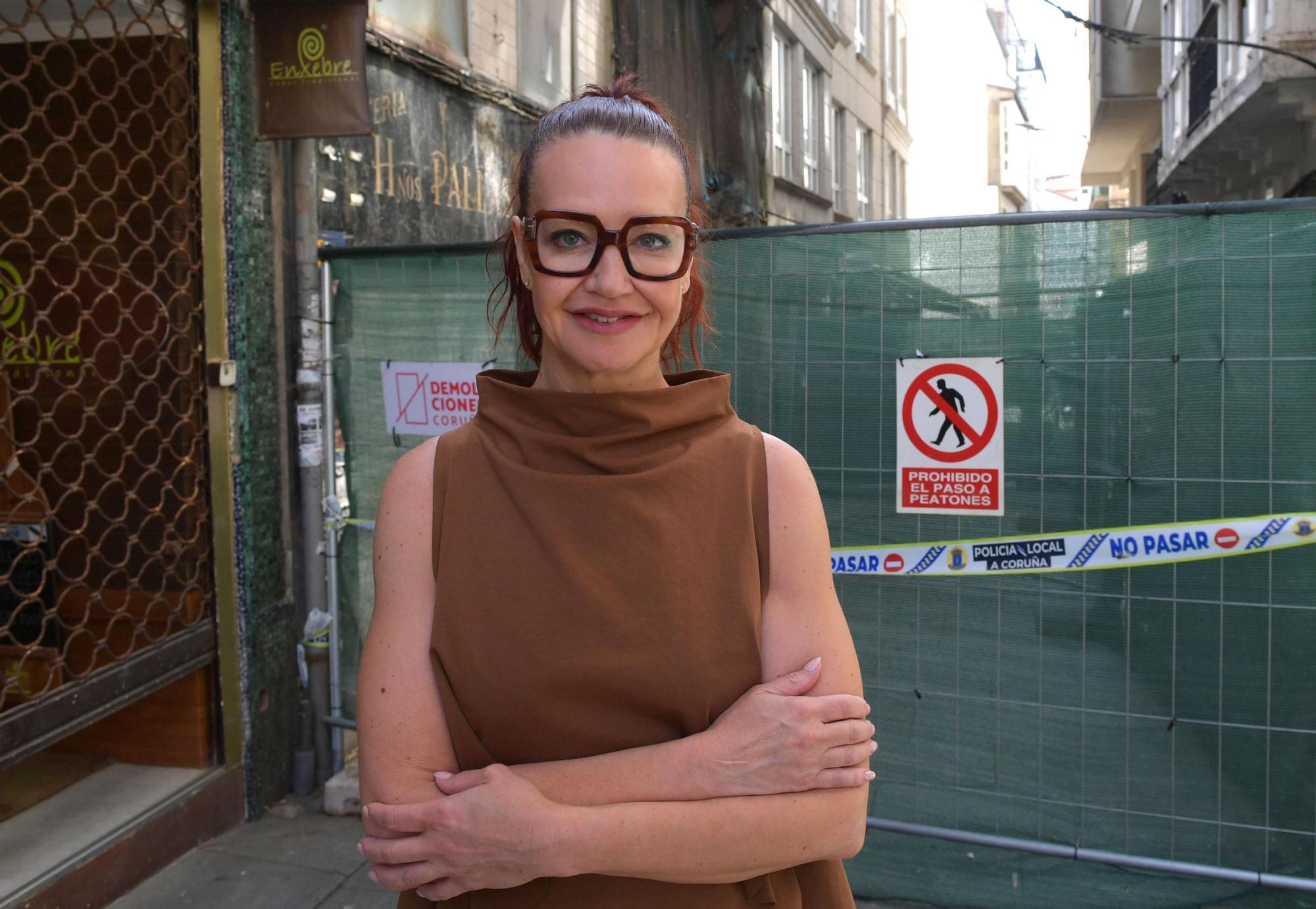 Paula San Emeterio, de la óptica Miroparamin, ante la valla de las obras en el edificio en ruinas de San Nicolás.